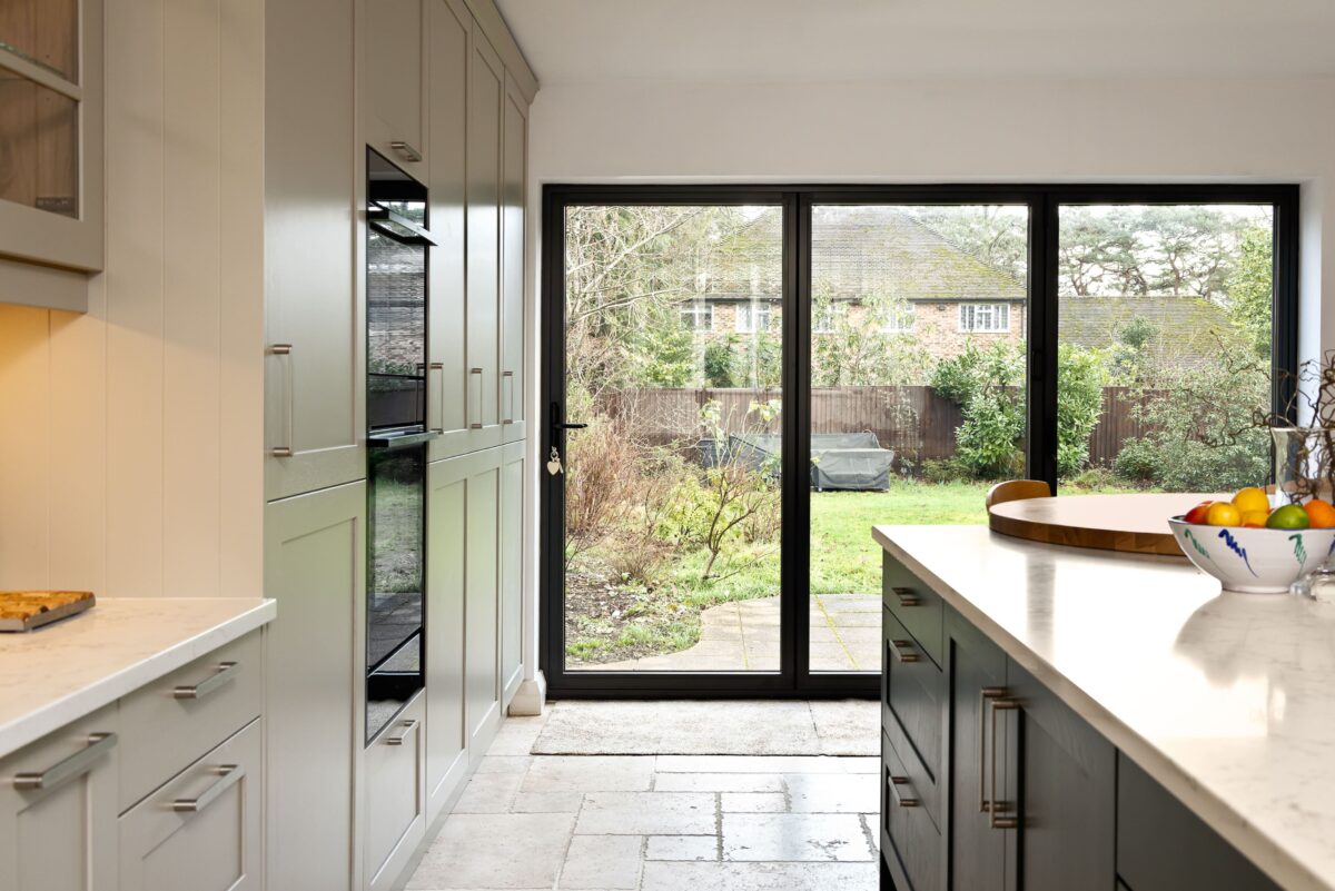 Family-friendly shaker kitchen with island, tall cabinetry and garden views in Camberley