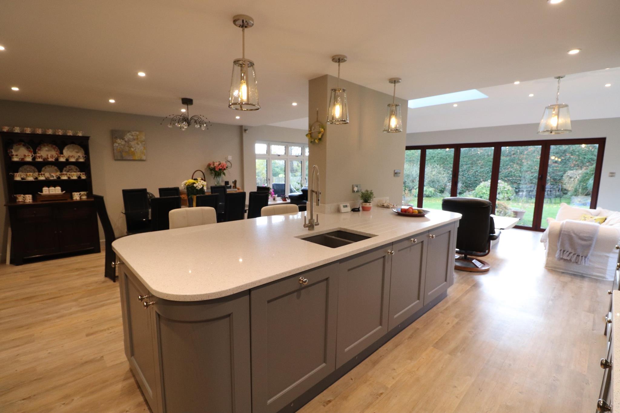 Large painted in-frame kitchen island with white quartz worktop and chrome pendant lights in open-plan kitchen — Inner Peace Interiors, Camberley