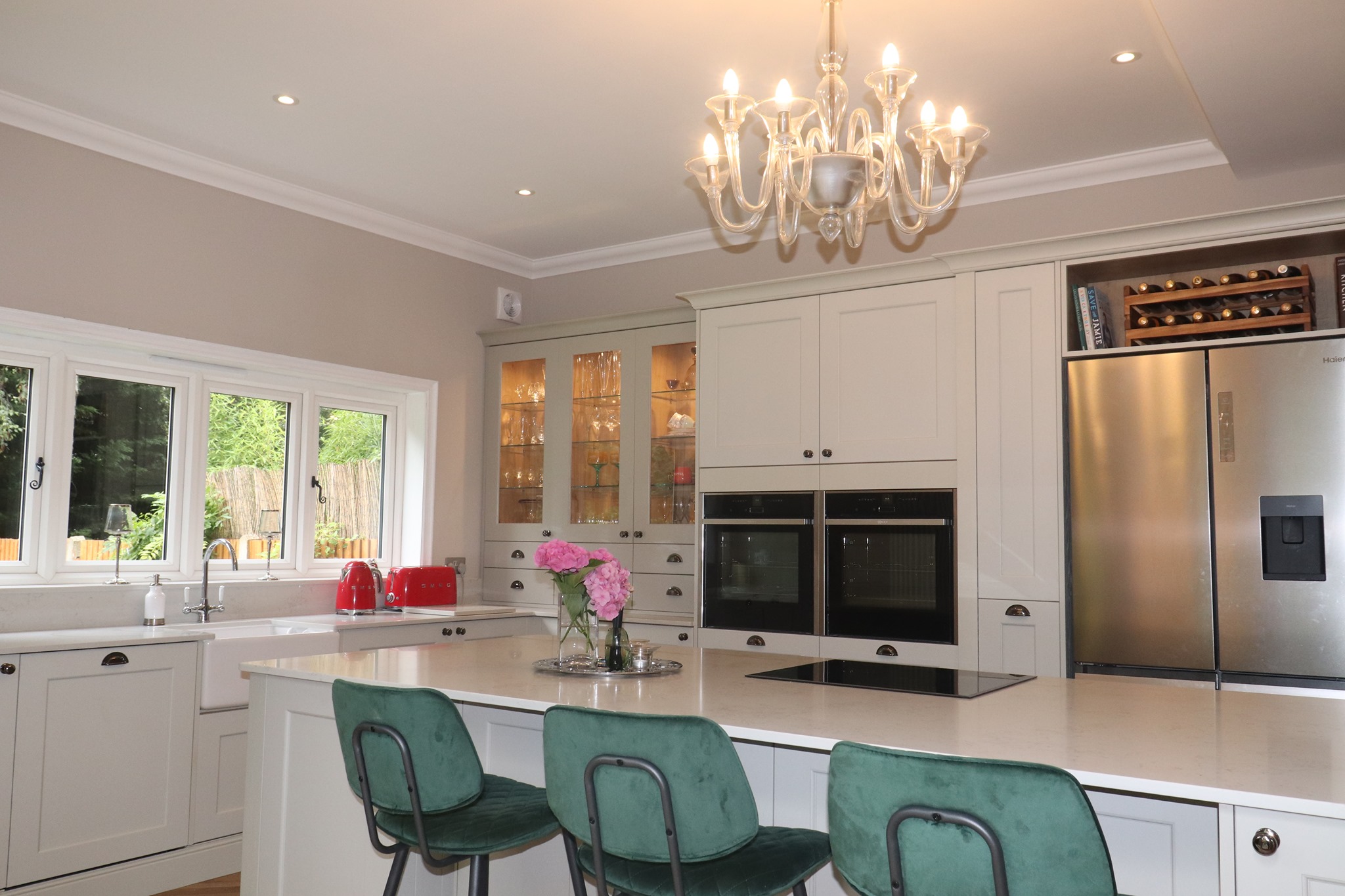 Classic shaker kitchen with island seating, built-in appliances and elegant lighting in Camberley