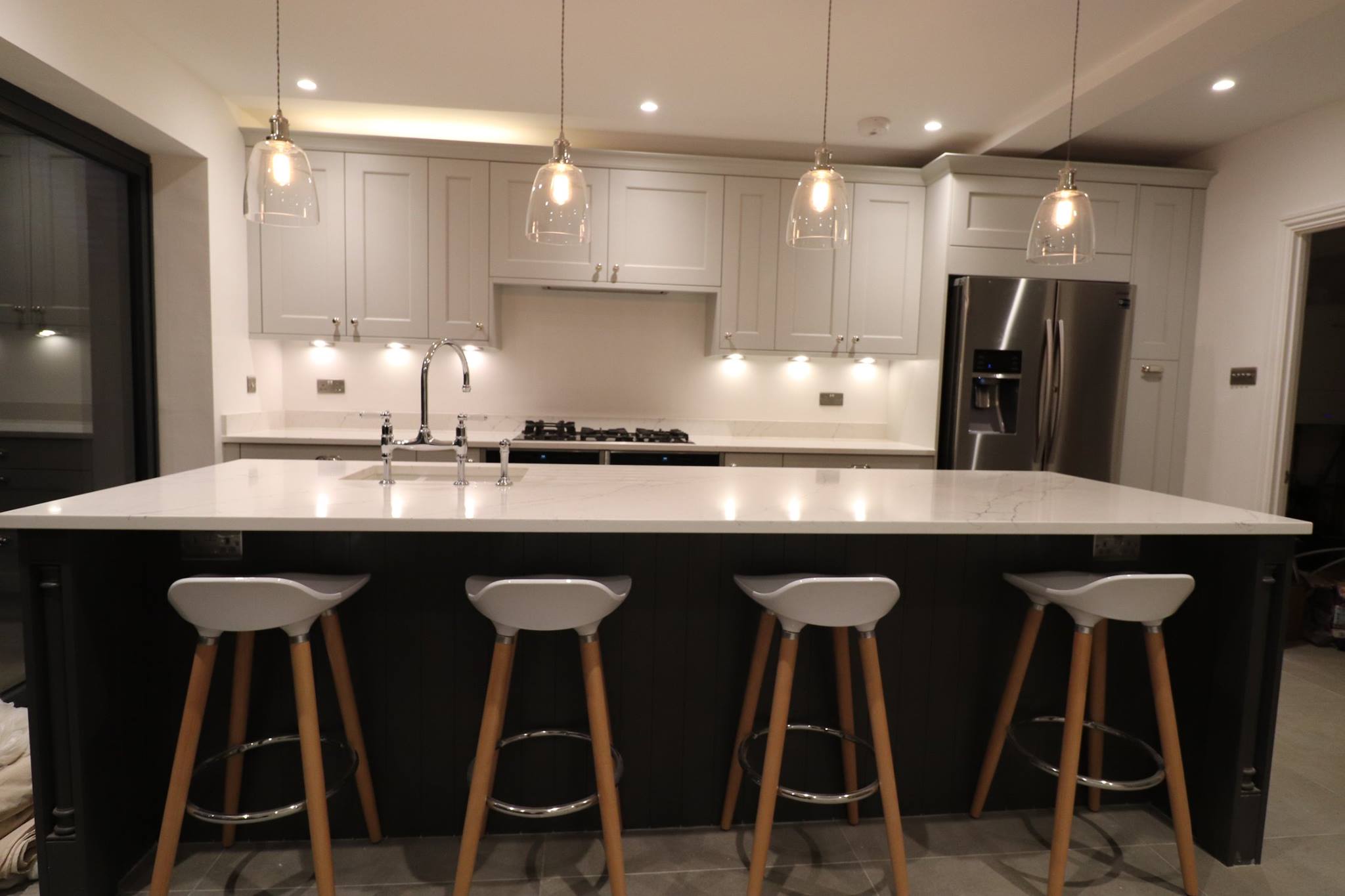 Shaker-style kitchen with large island, pendant lighting and breakfast bar seating