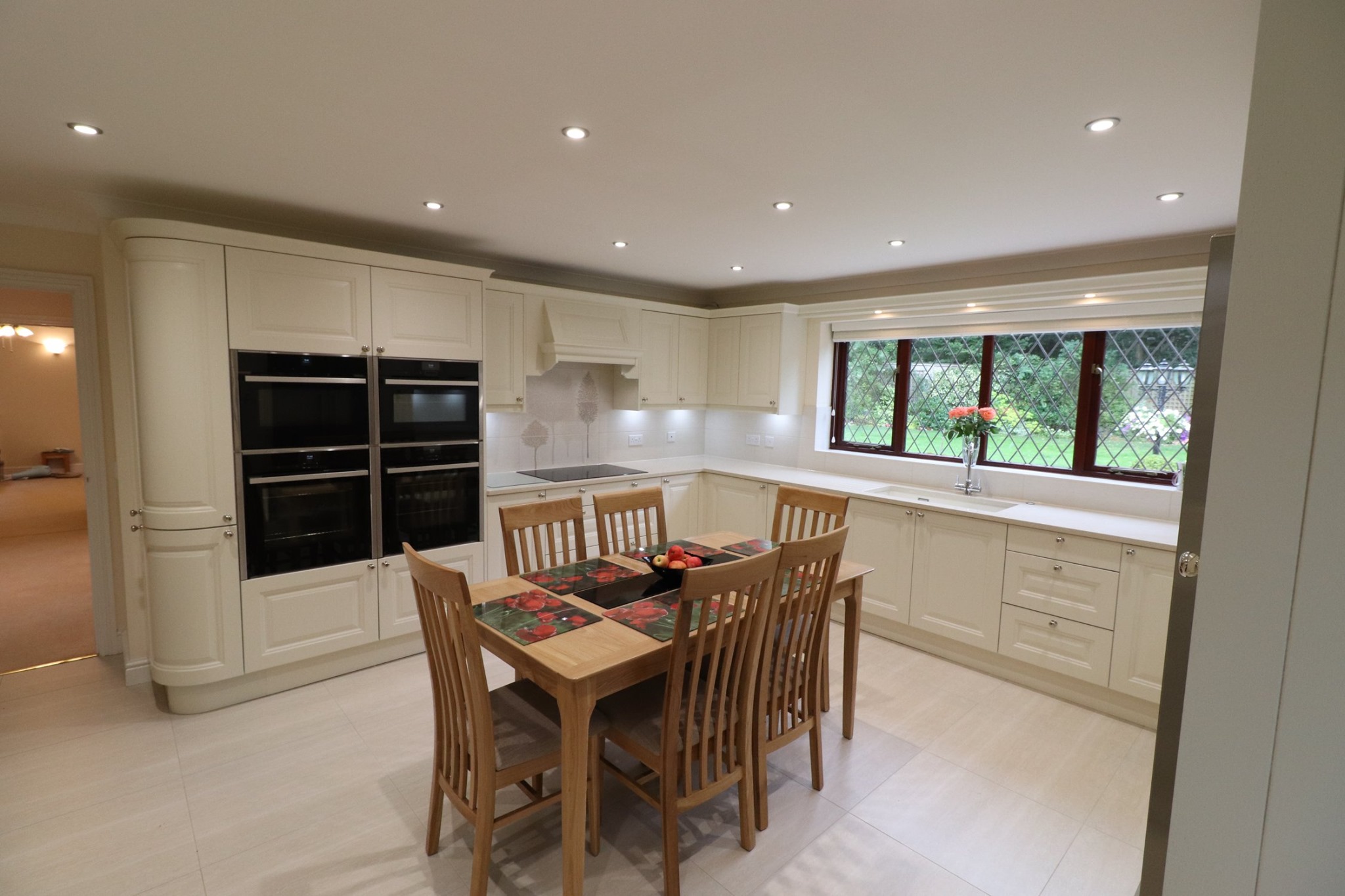 Traditional cream shaker kitchen with integrated appliances, dining table and large window