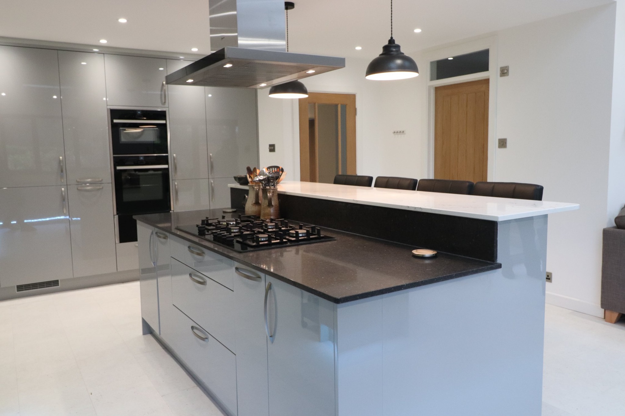 Contemporary kitchen with gloss grey cabinets, island hob and integrated appliances